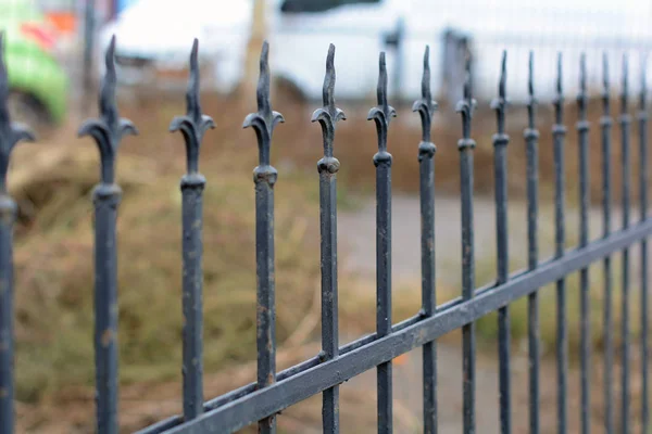Uma velha cerca forjada. Imagem de uma cerca de ferro fundido decorativo. Cerca forjada de metal. Cerca velha com forjamento artístico — Fotografia de Stock