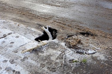 Asfalt yol kötü durumu nedeniyle yolda bir kaza tehlikesi. Çukur, kışın donma-çözülme çevrimleri neden olan bozuk asfalt yol. Kötü yol. 