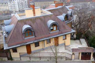 Budapeşte, Macaristan - 22 Aralık 2017: Kiremitli bir çatı, çatı windows ve baca sistemi ile Modern ev. Bir avlu içinde belgili tanımlık geçmiş eski şehir ile ev.