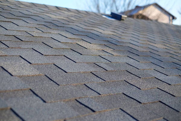Bitumen tile roof. Roof Shingles - Roofing. Close up view on Asphalt Roofing Shingles .