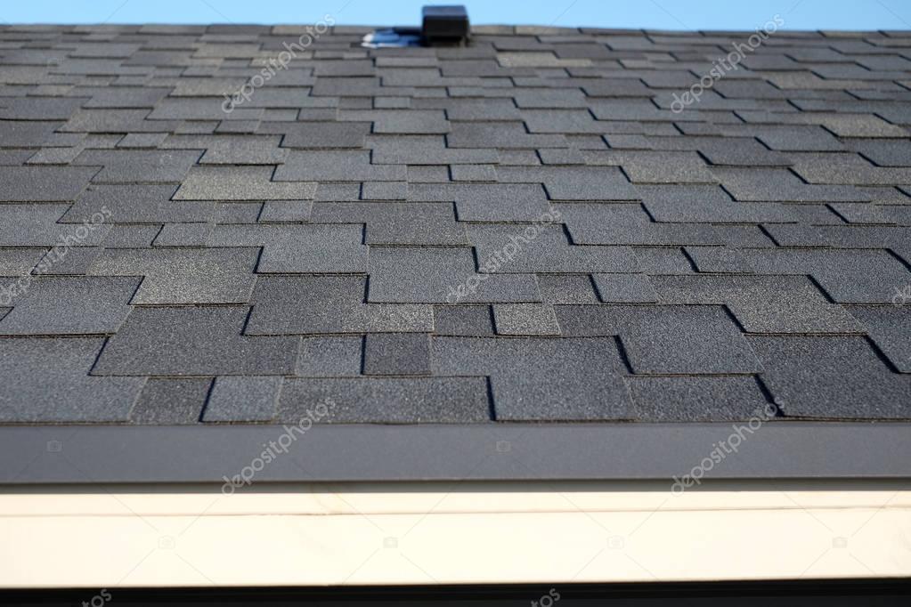 Close up view on Asphalt Roofing Shingles Background. Roof Shingles - Roofing. Bitumen tile roof.