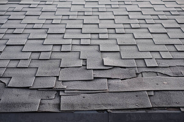 Shingles roof damage covered with frost. Close up view on Asphalt Roofing Shingles Background. Roof Shingles - Roofing. 