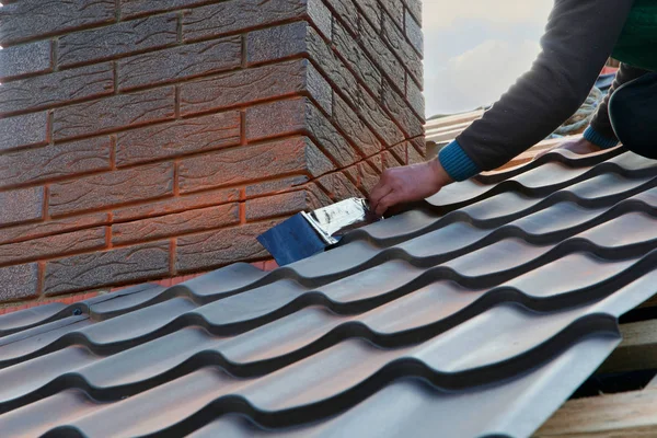 屋根葺き職人ビルダー ワーカーは 煙突に金属板を取り付けます 未完成の屋根工事 ストック写真