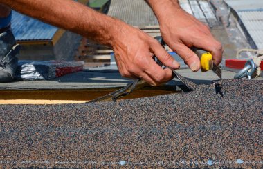 Repairing of roof by cutting felt or bitumen shingles during waterproofing works. clipart