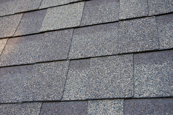 Close up view on asphalt roofing shingles background.                               