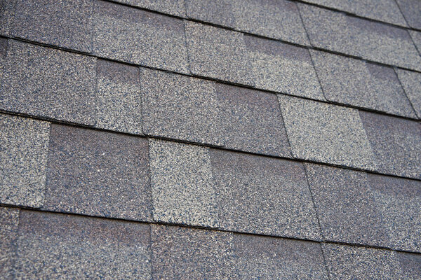 Close up view on asphalt roofing shingles background.                               