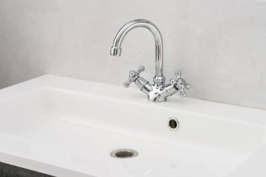 Banyo içi beyaz lavabo ve krom muslukla dolu..