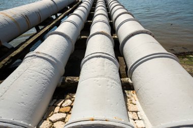 Elektrik santrali yakınlarındaki endüstriyel borular nehre dökülüyor. Çevre kirliliği kavramı.