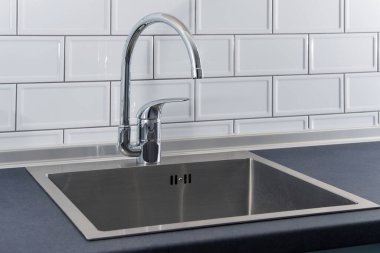 Modern mutfak metali musluğu ve paslanmaz çelik lavabo.