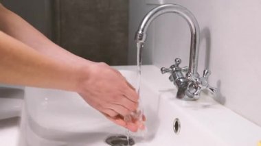 Lavaboda ellerini sabunla yıkayan genç bir kadının yakın çekimi. Coronavirus Covid 19 Önleme.