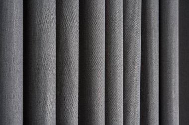 Yoğun kumaştan yapılmış ince ve kalın dikey kıvrımlara sahip perdenin yakın görüntüsü. Dokulu maddeler ve tekstil soyut arkaplan.