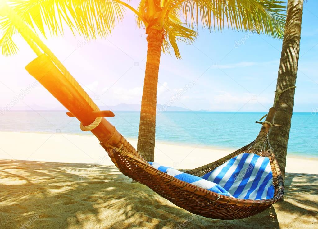 Beautiful beach.  Hammock between two palm trees on the beach. Holiday and vacation concept. Tropical beach.