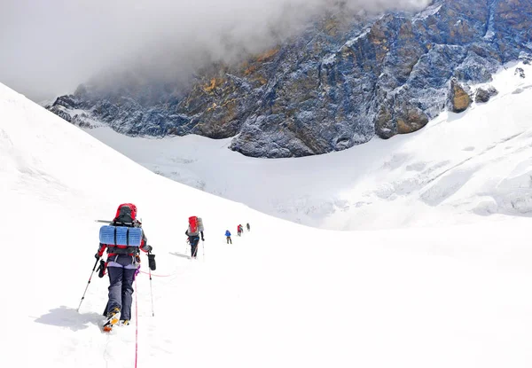Grupo de escaladores alcanza la cima de la cima de la montaña. Escalada y montañismo. Concepto de trabajo en equipo . — Foto de Stock