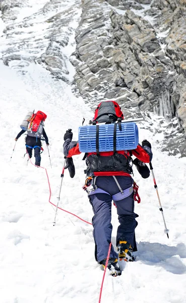 De klimmer bereikt de top van de bergtop. Klimmen en bergsport concept — Stockfoto