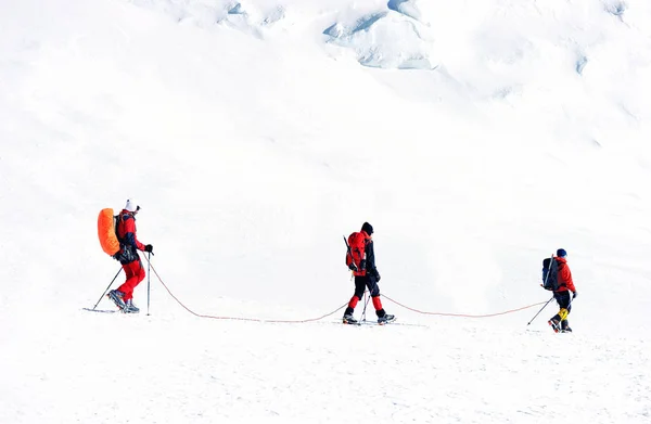 Grupo de escaladores alcanza la cima de la cima de la montaña. Escalada y montañismo. Concepto de trabajo en equipo . — Foto de Stock