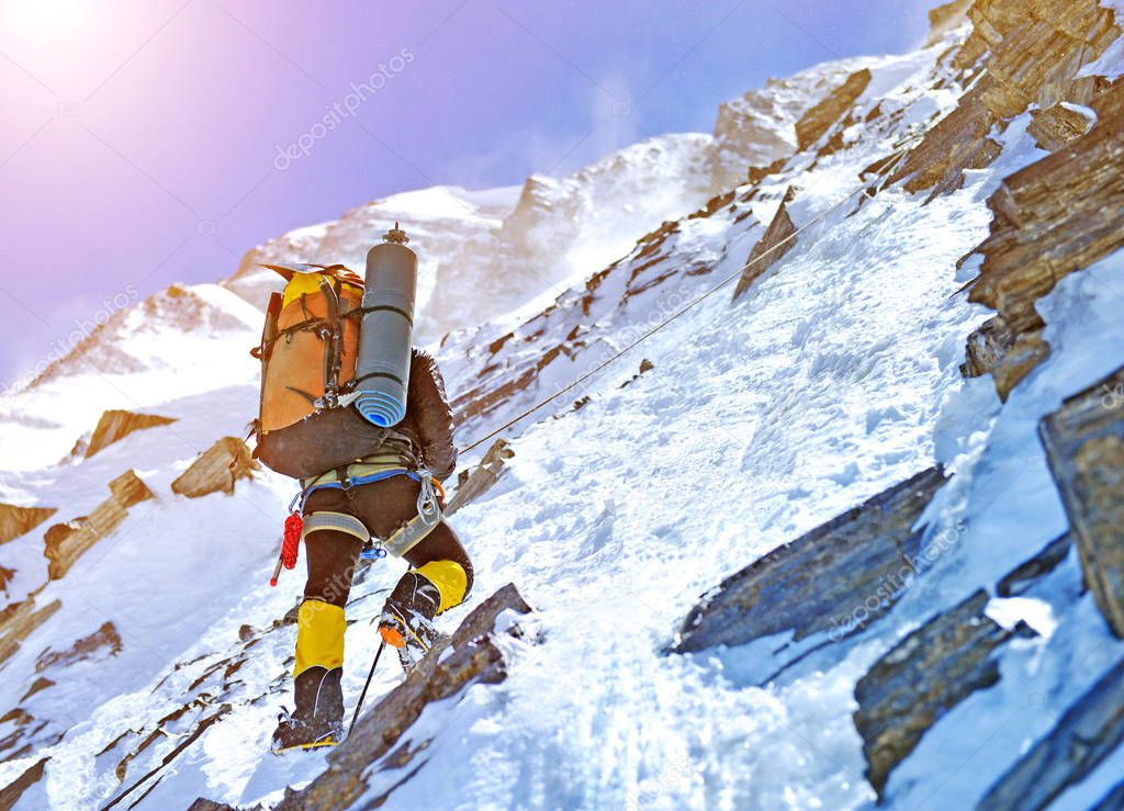 Climber reaches the summit of mountain peak. Climbing and mountaineering sport concept