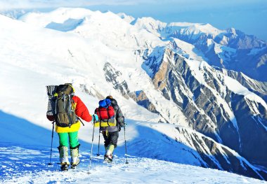 Bir grup dağcı dağın zirvesine ulaşır. Tırmanma ve dağcılık sporu. Takım çalışması konsepti.