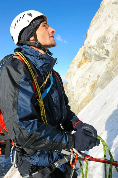 O alpinista atinge o cume do pico da montanha. Escalada e conceito de esporte de alpinismo — Fotografia de Stock