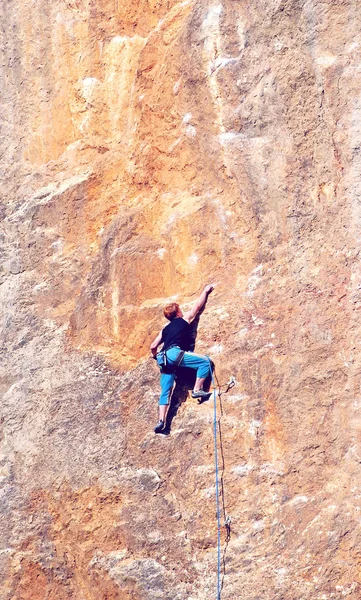 El escalador alcanza la cima del pico de la montaña. Escalada y montañismo concepto deportivo — Foto de Stock