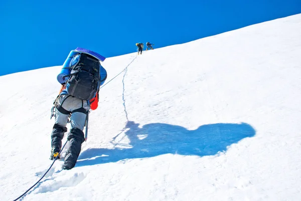 Grupo de alpinistas atinge o topo do pico da montanha. Escalada e esporte de alpinismo. Conceito de trabalho em equipa . — Fotografia de Stock