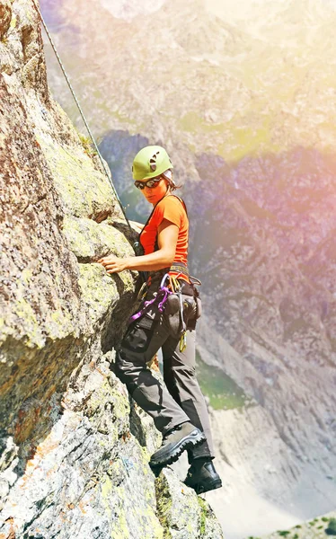 El escalador alcanza la cima del pico de la montaña. Escalada y montañismo concepto deportivo —  Fotos de Stock