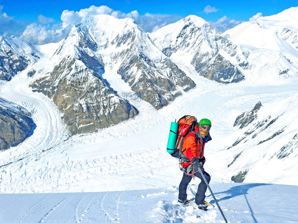 Climber reaches the summit of mountain peak. Climbing and mountaineering sport concept