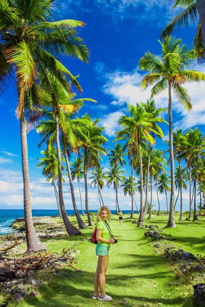 Молодая девушка путешествует по зеленой дороге с пальмами . — стоковое фото