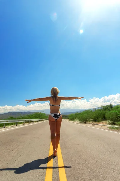 Mädchen im Bikini Rückansicht zu Fuß auf Asphaltstraße — Stockfoto