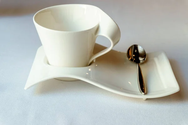 Designer blanc Coupe sur une soucoupe avec une cuillère à café — Photo