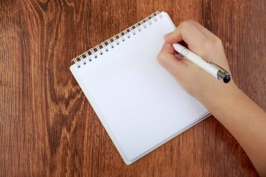 Üstten Görünüm boş defter ve kadın el kalem, boş alan ile. Kız yazılı mektup, kopya alanı. Düz ahşap zemin üzerinde yatıyordu