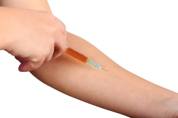Primer plano de la mano, dando la vacunación al paciente usando una jeringa con medicamentos marrones. Inyección estéril en el brazo . — Foto de Stock