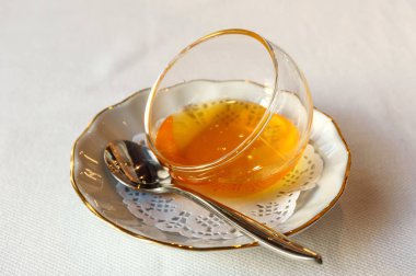 bir çay kaşığı beyaz plaka üzerinde bir cam vazoda tatlım