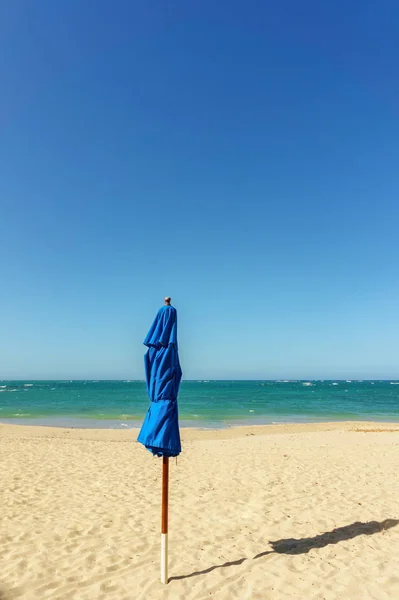 Sombrilla de playa azul cerrada con sombra en la playa de arena — Foto de Stock