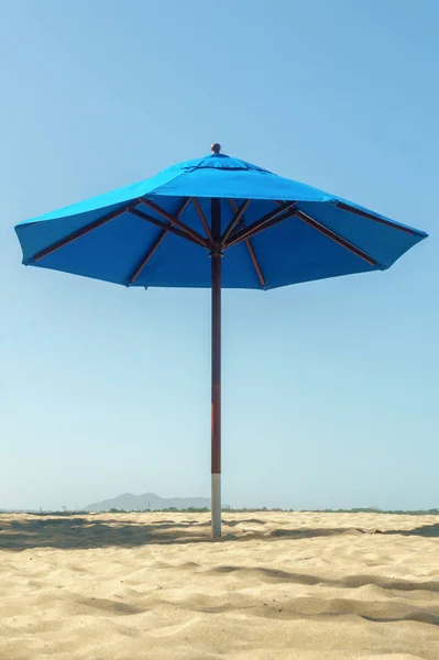 Sombrilla de playa azul abierto con sombra en la playa de arena — Foto de Stock