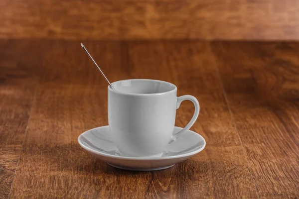 Tasse de café blanc avec cuillère sur soucoupe blanche sur fond en bois brun foncé — Photo