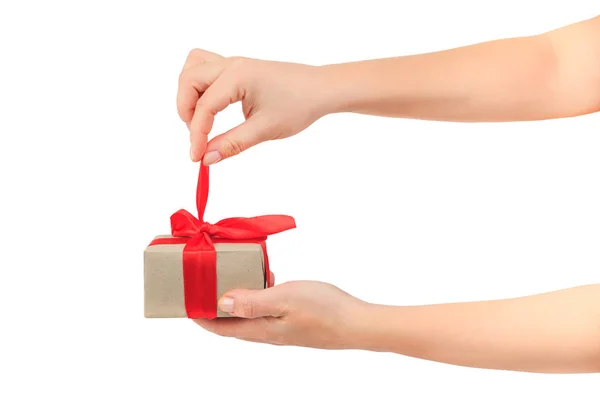 Women's hands untie the ribbon and open the gift Stock Picture