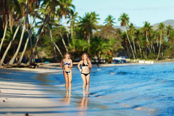 Dvě štíhlé dívky běží na tropické pláže — Stock fotografie