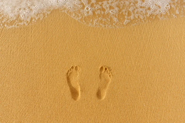 Par de pegadas na areia e no mar surf — Fotografia de Stock