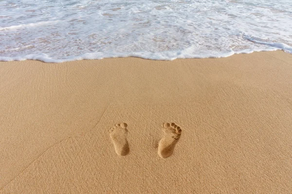 Par de huellas en la arena y el mar surf — Foto de Stock