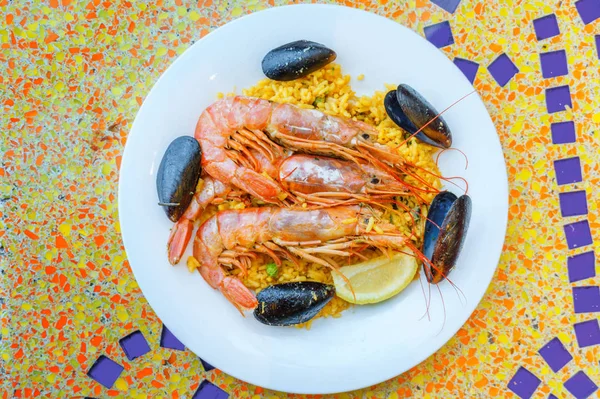 Porzione di paella, riso con gamberetti tigre, cozze e limone — Foto Stock