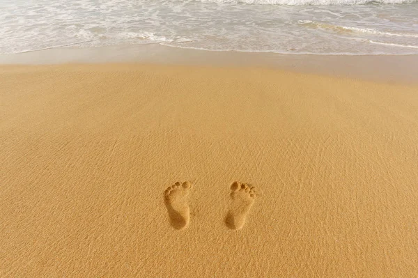 Par de huellas en la arena y el mar surf — Foto de Stock