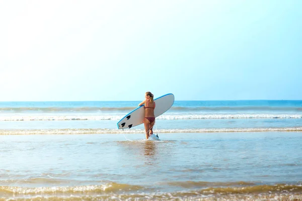サーフボードと白い金髪のサーファーの女の子は海に行く — ストック写真