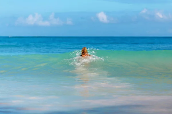 Mädchen schwimmt ins blaue Meer — Stockfoto
