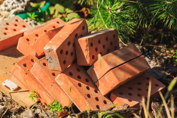 a bunch of bricks lay on the ground under the tree