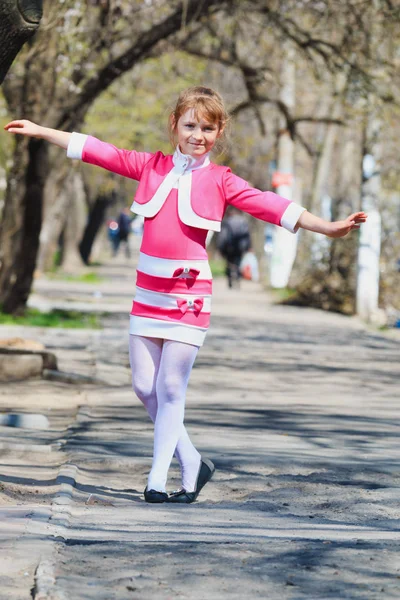 Mignonne petite fille avec tresse dans une robe rose dansant en plein air — Photo
