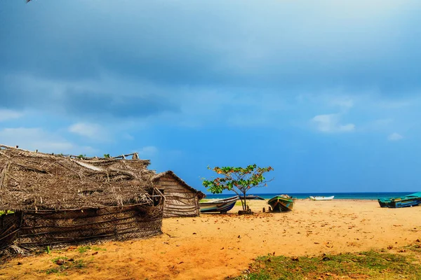 Σπίτι φύλλα thatched καρύδας ή καλύβα αλιείας και σκαφών σε τροπική παραλία — Φωτογραφία Αρχείου
