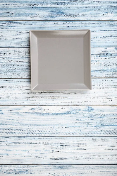 Пустая прямоугольная плита на фоне деревянного стола — стоковое фото