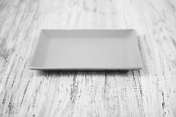 Пустая прямоугольная плита на фоне деревянного стола — стоковое фото