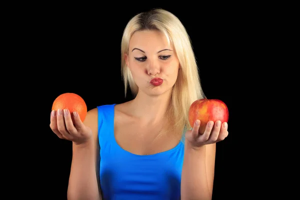 Meisje houdt en kiest voor Apple of oranje — Stockfoto