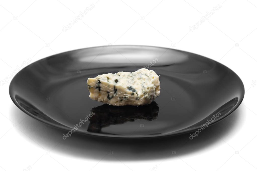 Piece of blue cheese with mold on black plate